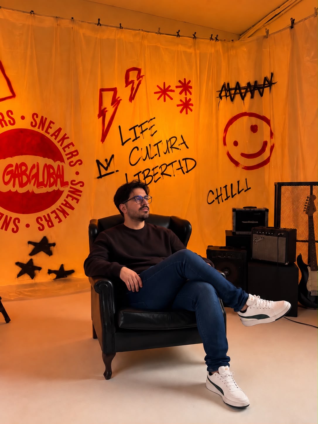 Alcides Gabriel sentado en un sillón en el estudio de Gab Global, con grafitis de la marca de fondo
